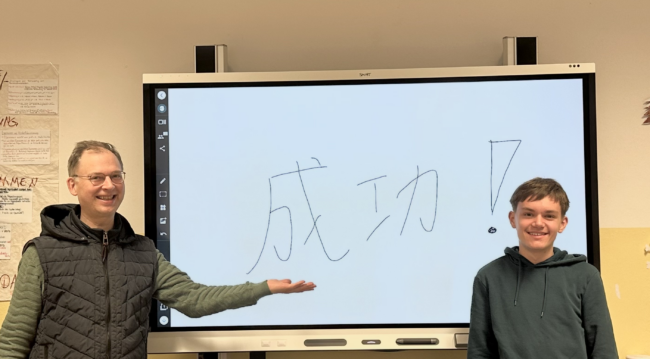 Fabian hat den Chinesischtest bestanden an der Tafel steht Erfolg in chinesischen Zeichen